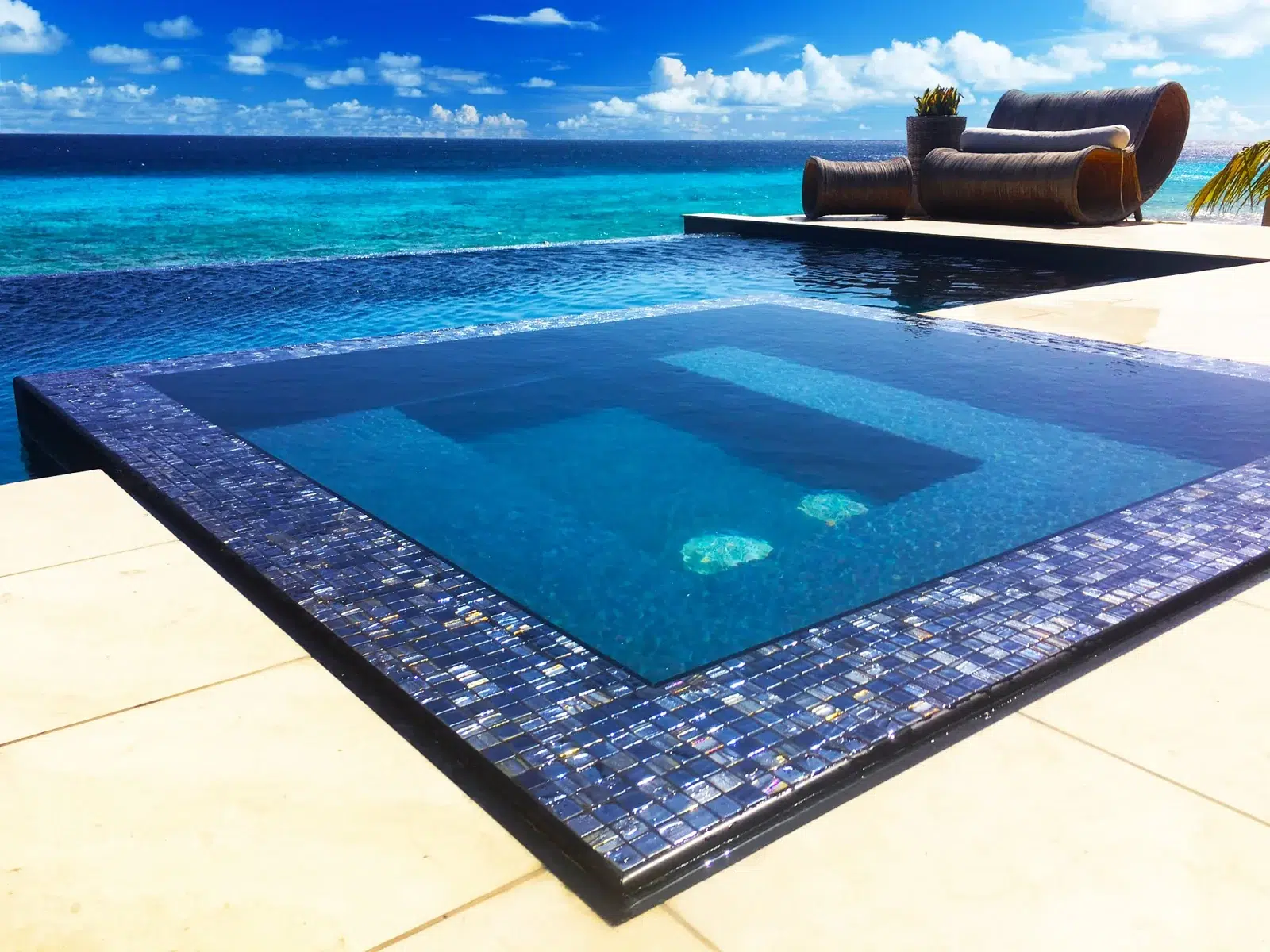 Finished swimming pool with an integrated spa and poolside lounge chair