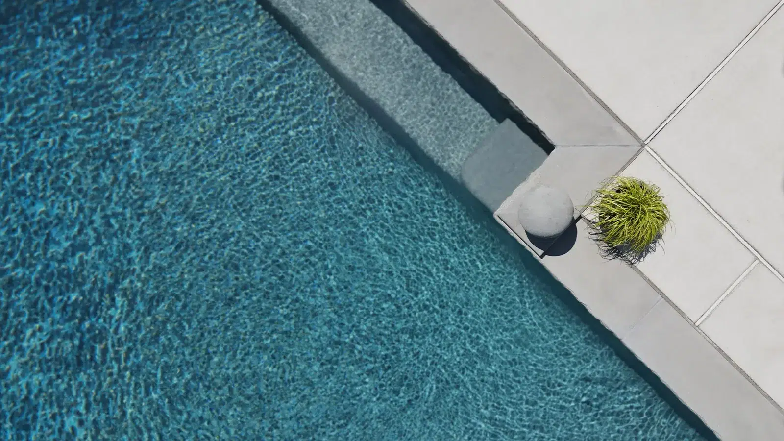 Close view of a speckled swimming pool finish beneath clear water