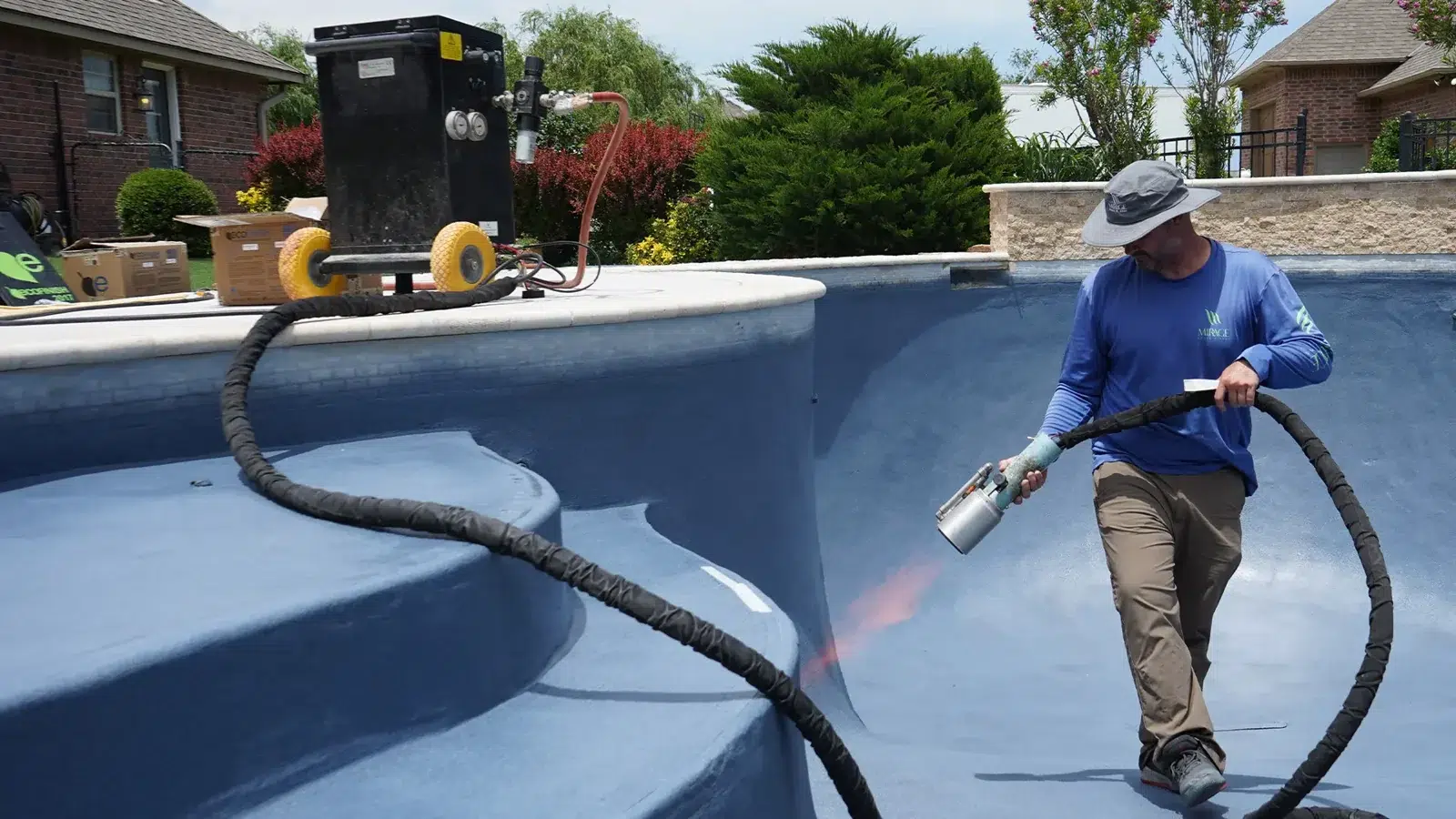 Pool coating technician working inside a drained swimming pool